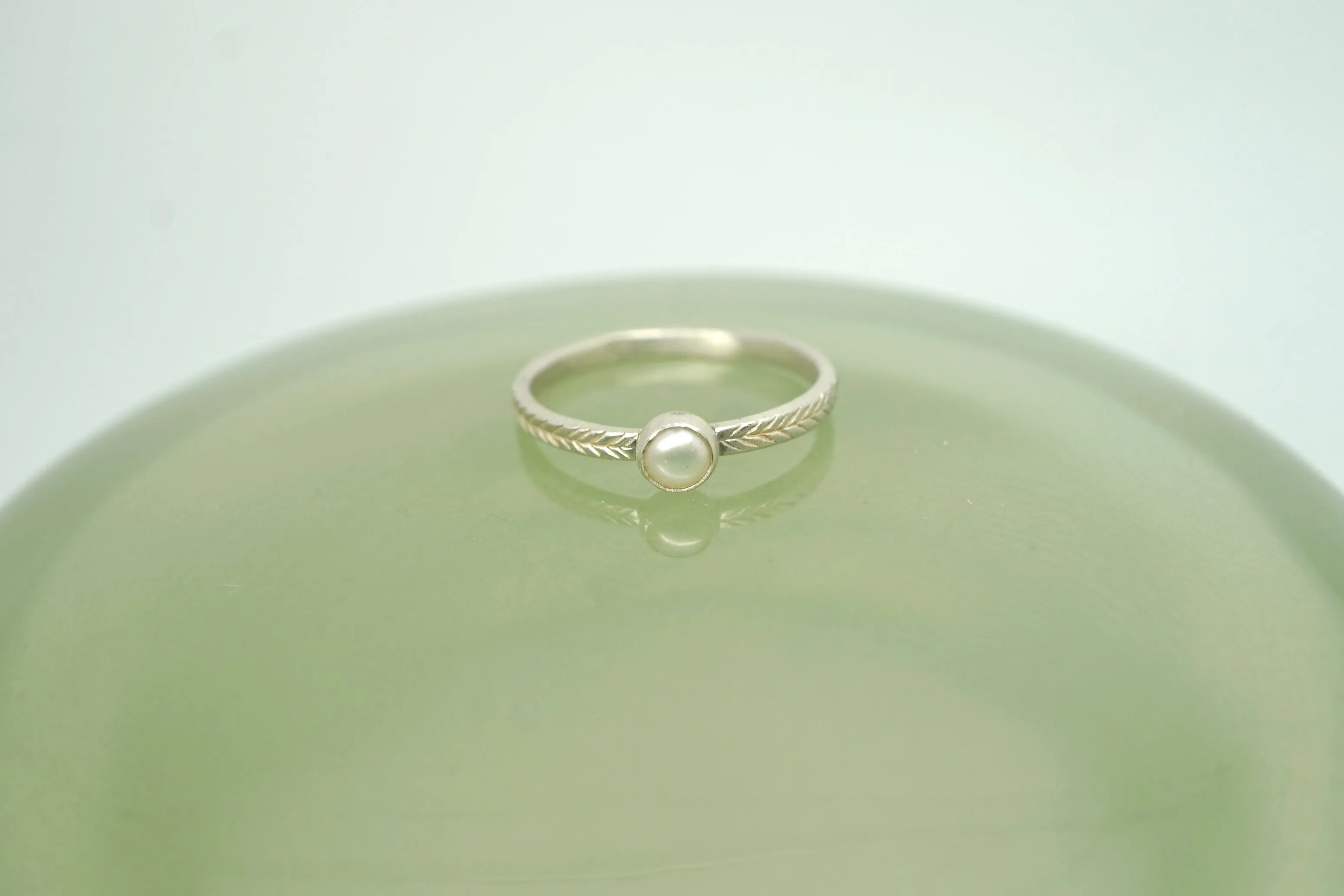 Pearl ring with hand-carved feather textures